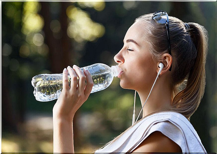 Woman drinks water during exercise.