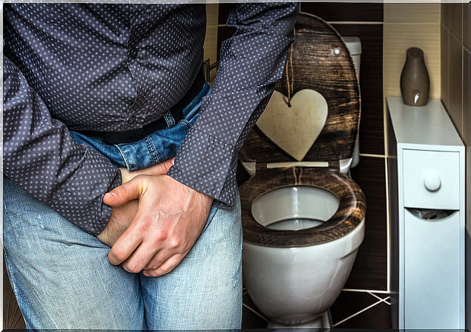 Man in bathroom with hands on genital area: Foley catheter for urinary incontinence