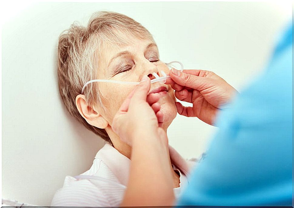 Male nurse applying a nasogastric tube to an elderly woman.