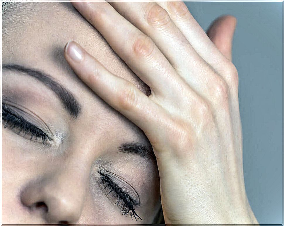 woman with hand on face for headache.